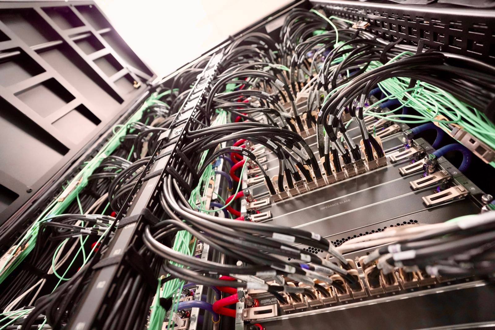 Dense network cabling and hardware inside a data centre rack.